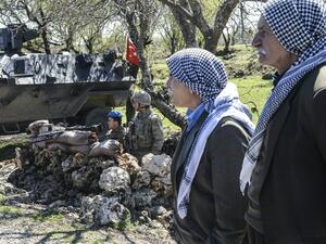 Kurdish men wait in front of Turkish military barricade as they try to enter Cizre for Newroz celebration in Mardin, on March 22, 2016. (AFP/Ilyas Akengin)
