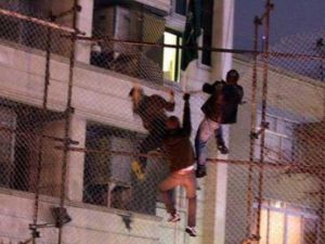 متظاهرون يتسلقون سياج القنصيلة قبل احراقها