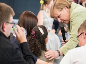 ميركل تربت على كتف الطفلة الباكية