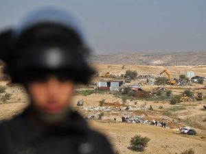Israeli policemen stand guard as bulldozers demolish homes in the Bedouin village of Um al-Hiran (AFP/File Photo)	