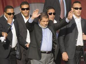 In better times: Flanked by bodyguards, Morsi saluted tens of thousands of Egyptians Tahrir Square on June 29, 2012, when he symbolically swore himself in as the country's first elected civilian president. (AFP PHOTO/MOHAMMED HOSSAM)