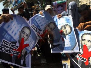 Relatives of prisoners of Palestinians held in Israeli jails burn pictures of US President Barack Obama during a protest against his visit to the region at the Jabalyia refugee camp, in the northern Gaza Strip. (AFP PHOTO / MAHMUD HAMS)
