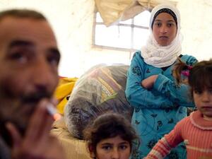 A Syrian refugee family gathers inside a tent after fleeing from the northern Syrian town of Darkush.( AFP PHOTO / ODD ANDERSEN)