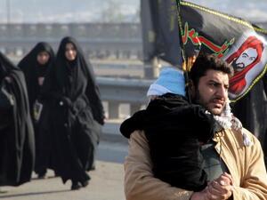 Clutching at straws: an Iraqi man holds on to his child on the main highway into the capital (used for illustrative purposes only)
