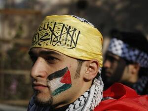 A Palestian wearing the trademark chequerred keffieyh with a national flag painted on his face, attends a rally in support of president Mahmoud Abbas's Farah party on Friday in Gaza City. (AFP PHOTO / MOHAMMED ABED)
