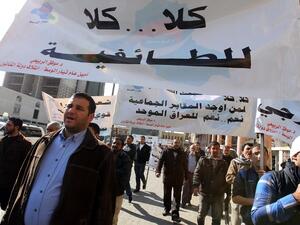 Supporters of Iraqi Prime Minister Nuri al-Maliki hold a banner reading "No to sectarianism" during a demonstration at Tahrir Square in Baghdad. (AFP PHOTO/SABAH ARAR)