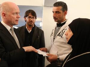 British Foreign Secretary of State for Foreign Affairs William Hague (L) talks with Syrian refugees (R and 2ndR) at a World Food Programme Center in Burj Hammoud's area on the northern outskirts of Beirut. (AFP PHOTO POOL MOMAMED AZAKIR)
