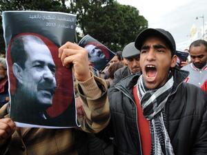 A Tunisian protestor holds a placard featuring killed opposition leader Chokri Belaid during a demonstration. (AFP PHOTO / FETHI BELAID)