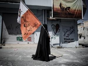 A Bahraini woman holds up her national flag decorated with anti-government slogans in the village of Jidhafs, west of Manama. (AFP PHOTO/MOHAMMED AL-SHAIKH)