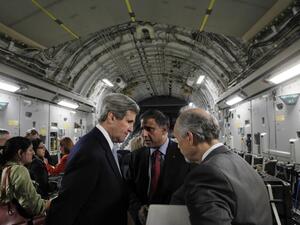 U.S. Secretary of State John Kerry speaks with Puneet Talwar (C), the National Security Council's Senior Director with responsibilities for Iran, Iraq, and the Gulf countries, and another advisor aboard an Air Force C-17 aircraft during their return to Amman from a trip to Baghdad. (AFP PHOTO/JASON REED/POOL)