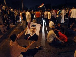 An Egyptian supporter of deposed president Mohammed Morsi holds his portrait during a sit-in protest outside the presidential palace in Cairo on July 13, 2013 (AFP/PHOTO/MAHMOUD KHALED)