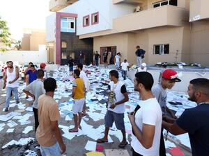LIBYA, Tripoli : Libyan protesters stand amidst scattered documents after ransacking the offices of Muslim Brotherhood-backed Party of Justice and Construction, in the Libyan capital Tripoli on July 27, 2013. AFP PHOTO/MAHMUD TURKIA
