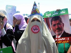 A supporter of Egypt's deposed president Mohamed Morsi, wearing a pin which reads in Arabic "Peaceful", attends a demonstration in the Mediterranean city of Alexandria on August 3, 2013. (AFP)