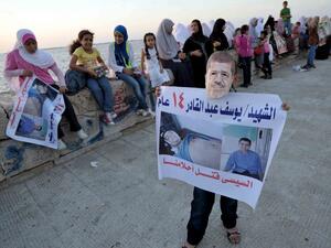 A supporter wears a mask of Egypt's deposed president Mohamed Morsi showing a portrait of a child, victim of the clashes during a protest in the Mediterranean city of Alexandria on August 6, 2013. (AFP)