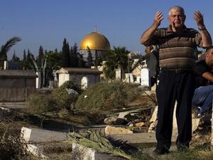Palestinians visit the graves of loved ones at a Muslim cemetery near the Al-Aqsa Mosque compound as part of the Eid Al-Fitr holiday in the old city of Jerusalem on August 8, 2013. (AFP)
