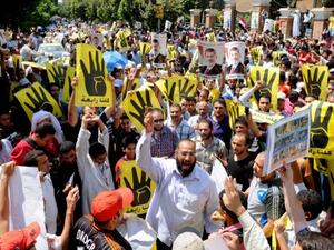 Supporters of the Muslim Brotherhood and Egypt's toppled president Mohamed Morsi (portrait) take part in a demonstration in Hilwan, south of Cairo, on August 30, 2013. (AFP)