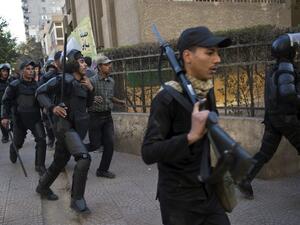 Egyptian riot policemen run after Muslim brotherhood members following a demonstration in Cairo's eastern Nasr City district on December 27, 2013. [AFP]