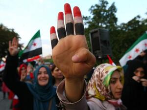A woman raises her hand painted with the colors of the Egyptian flag among other protesters staging a demonstration in the Turkish capital in Ankara on August 19, 2013. (AFP)