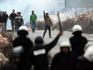 Youth from the Palestinian refugee camp of al-Jalazoun, clash with Palestinian police as they block the main road leading to the West Bank city of Ramallah and Bir Zeit as they protest against the reduction of aid to refugees given by United Nation's UNRWA on January 12, 2014. [AFP]