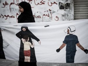 A Bahraini protester holds a banner during an anti-regime rally in solidarity with jailed political activists and against the upcoming Bahrain Formula One Grand Prix. (TOPSHOTS/AFP PHOTO/MOHAMMED AL-SHAIKH)