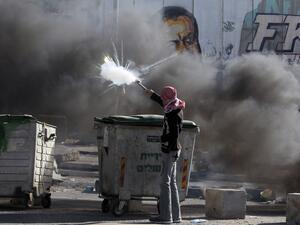 A Palestinian youth clashes with Israeli border guards in the West Bank's Qalandiya refugee camp on August 26, 2013, after Israeli security forces shot dead three Palestinians and wounded 19 others in the camp. (AFP)