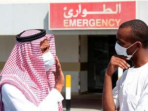 Men wearing surgical masks as a precautionary measure against the novel coronavirus, speak at a hospital in Khobar city in Dammam May 23, 2013. 