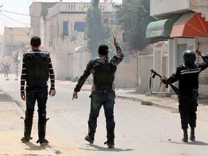 Security forces gesture towards Ansar Al Sharia protestors in the Ettadhamen, Tunisia on Sunday. AFP