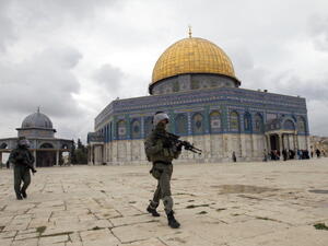 Israeli riot police walk towards stone-throwers as pass the Dome of the Rock mosque following Friday prayers. [Getty Images]