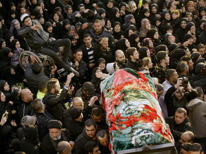 People carry one of the two bodies during the funeral of Malak Zahwa and her step-mother Iman Hijazi, who both died in a car bomb that targeted a Beirut's suburb the day before on January 3, 2014. [Getty Images]