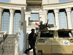 An Egyptian policeman talks to a soldier manning an armoured personnel carrier outside the Egyptian Constitutional Court in Cairo on Monday (AFP photo)