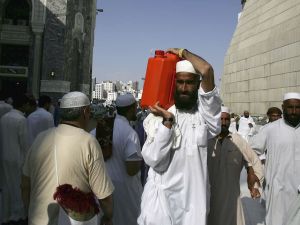 A Muslim pilgrim carries a gallon container of water from the Zamzam well the source of which comes from under the great mosque, Mecca.