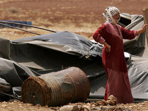 A Palestinian bedouin woman stands next to her destroyed tent in the village of Atouf in the Jordan Valley (AFP/File)
