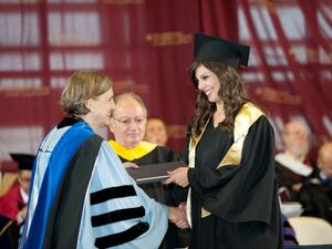 AUC undergraduate student receiving her degree from AUC President