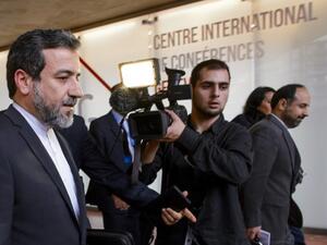 Iran's Deputy Foreign minister Abbas Araqhchi (L) leaves the media center after the start of two days of closed-door nuclear talks on October 15, 2013 at the United Nations offices in Geneva. (AFP)
