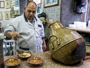 A Jordanian man prepares hummus to be served with falafel.