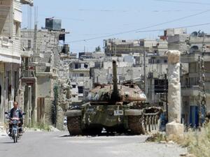 A man rides his motorbike past a burnt out Syrian Army tank in a central Homs province earlier this week. AFP image