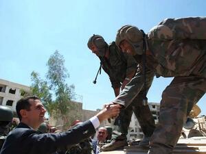 Syrian President Bashar Assad greets Syrian army soldiers during a visit in Daraya, southwestern of the capital Damascus on 1st August. (AFP/SANA)