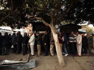 Egyptian men partake in the referendum, at a polling station in Cairo  to cast their votes on a new constitution, December 15