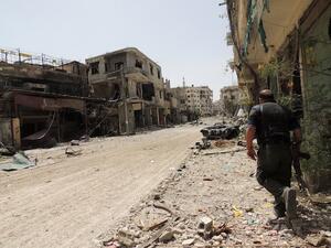 A Syrian rebel walks in a heavily damaged street in Arbeen in the outskirts of Damascus . AFP Photo