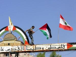 فلسطيني يعتلي لافتة في مخيم عين الحلوة