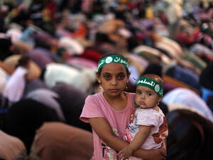 An Egyptian girl holds a baby as supporters of the Muslim Brotherhood pray on July 10, 2013. (source: AFP PHOTO / MAHMUD HAMS)