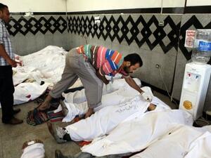 Men check the IDs of dead Muslim Brotherhood supporters, at a field hospital in Cairo, on July 27, 2013 (AFP)
