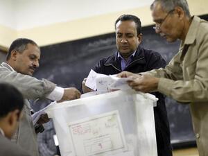 Polling station officials count ballots in Cairo on Saturday at the end of the first day of vote in a referendum on a new constitution. (AFP PHOTO/MAHMOUD KHALED)