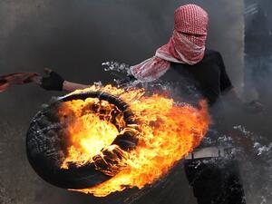 A Palestinian sets fire to a tyre during clashes between hundreds of Palestinians and Israeli soldiers earlier this year in Hebron. (file AFP)