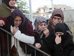 Female mourners grieve during the funeral of 14-year-old Palestinian Waji al-Ramhi in the Jelazoun refugee camp in the West Bank city of Ramallah on December 8, 2013. (AFP)