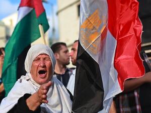 A Palestinian supporter of ousted Egyptian president Mohamed Morsi, shouts slogans as she stands in between the Egyptian (R) and Palestinian flags during a protest against the violence in the Egyptian capital on August 14, 2013, in Gaza City. (AFP)