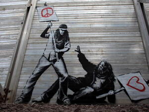 Art work said to be by underground artist Banksy is seen on the fence at the Glastonbury Festival site at Worthy Farm, Pilton on June 24, 2010 in Glastonbury, England.