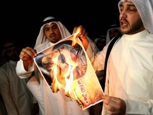 Kuwaiti protesters set ablaze a picture of Hezbollah's chief Hassan Nasrallah during a protest in front the Lebanese embassy against Hezbollah's and Iran's involvement in Syria on Tuesday. AFP photo