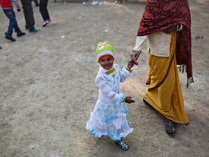 An Indian girl walks with her mother