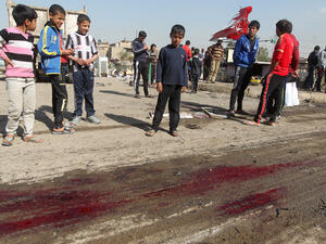Iraqi children gather around blood stains at the site of a car bomb attack in Baghdad's impoverished district of Sadr City on Sunday. A series of bombings mainly targeting Shiite areas of Baghdad killed at least 21 people, officials said, in the latest violence to hit Iraq as it struggles with protests and a political crisis. (AFP Photo/Ahmad al-Rubaye)